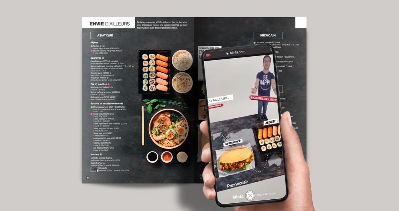 Un catalogue ouvert avec un plateau de sushi et un bol de nouilles et un portable qui scanne le catalogue.