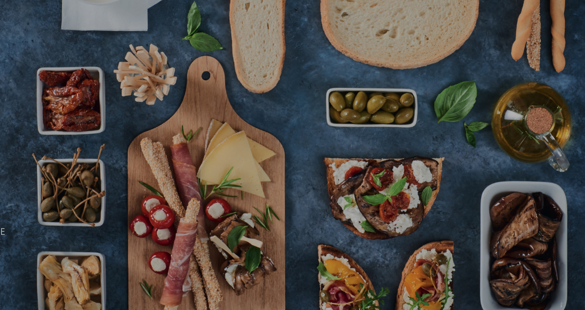 Une table d’apéritif avec des tartines, une planche et des ramequins