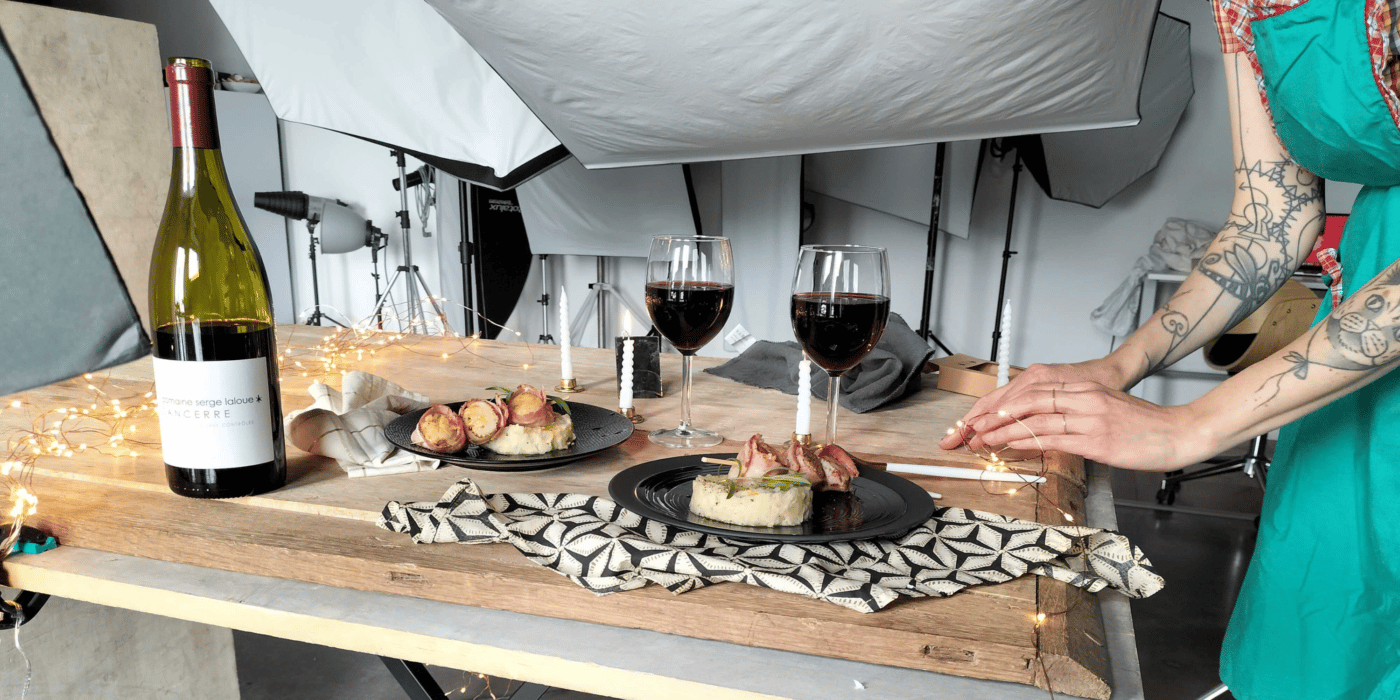 Deux assiettes et deux verres de vin avec bouteille sur table en bois