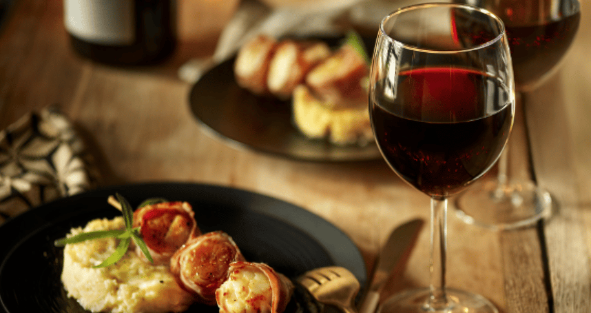 Assiette garnie avec verre de vin rouge sur table en bois
